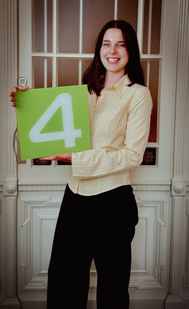 IMG_7232 Auf diesem Foto ist unsere Kundenberaterin Michelle Hempel vor einer Tür mit einer grünen 4 in der Hand zu sehen.
