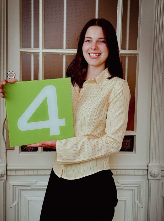 IMG_7232 Auf diesem Foto ist unsere Kundenberaterin Michelle Hempel vor einer Tür mit einer grünen 4 in der Hand zu sehen.